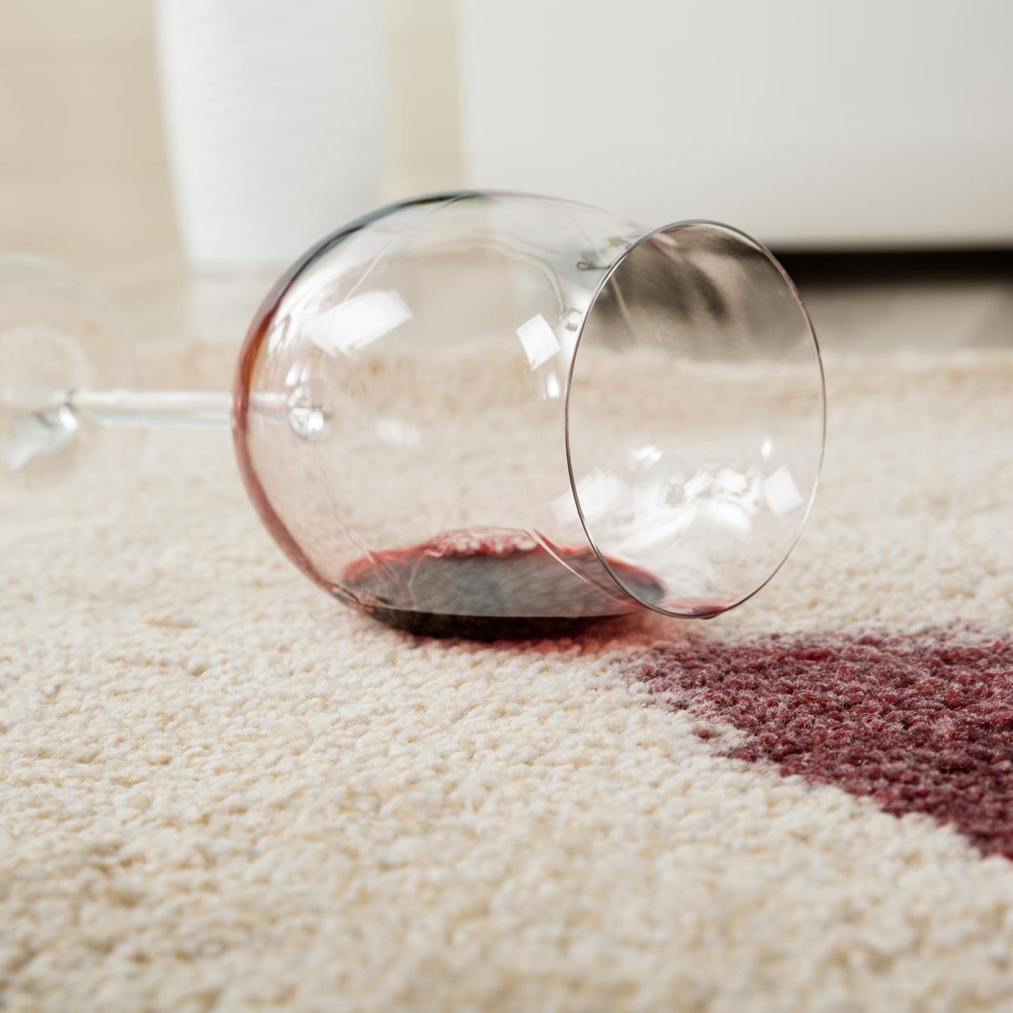 Oh Schreck ein Fleck: Ein umgefallenes Rotweinglas auf einem hellen Teppich