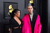 Kourtney Kardashian und Travis Barker tragen auf dem Red Carpet dezente Looks in Schwarz, beim fuchsiafarbenen Satin-Mantel ihres Verlobten kann Kourtney ihren Blick aber nicht von ihm abwenden.
