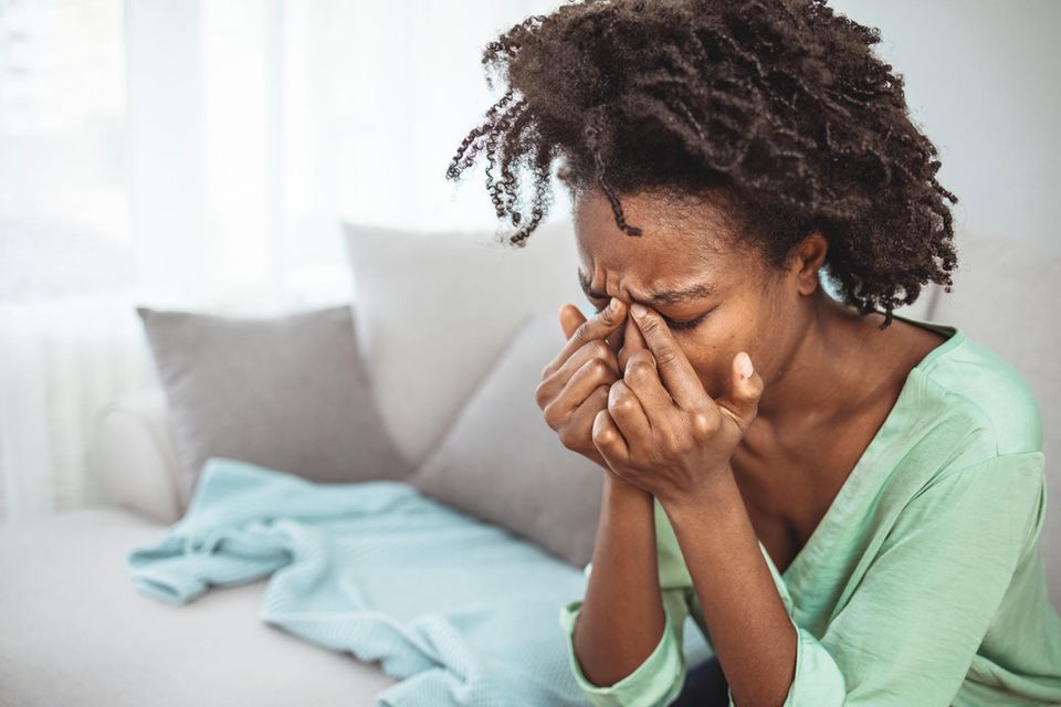 Frau mit Kofpschmerzen: Was du laut der 10-20-Regel bei der Einnahme von Schmerzmitteln beachten solltest