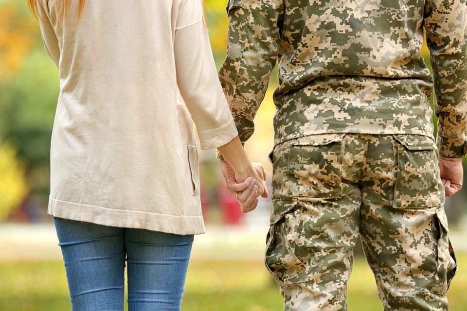 Soldatenfrau hält Hand ihres Mannes