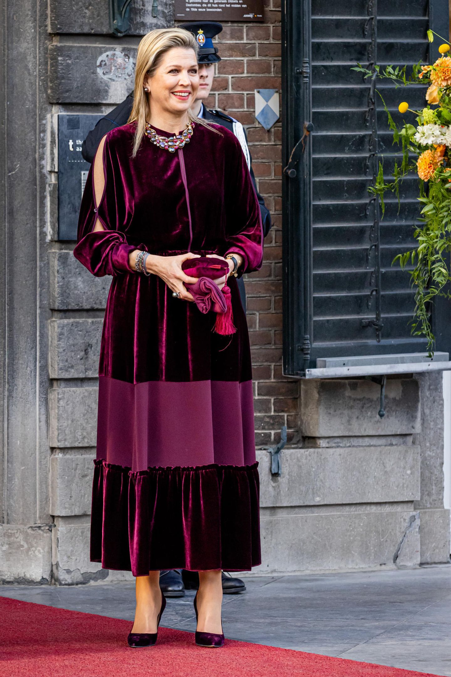 Königin Máxima besucht das Königstag-Konzert in Maastricht. Dafür ist sie wieder einmal gewohnt stilsicher gekleidet: Sie trägt ein langes Samtkleid in Bordeaux-Rot mit großen Arm-Ausschnitten. Dazu kombiniert sie sowohl die passenden Schuhe und Tasche als auch auffälligen Statement-Schmuck, der super zu den schlichten Haaren passt.