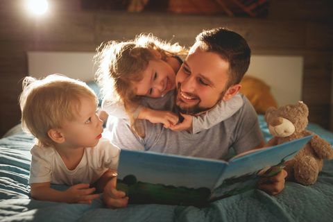 Mann liest Kindern Gute-Nacht-Geschichte vor