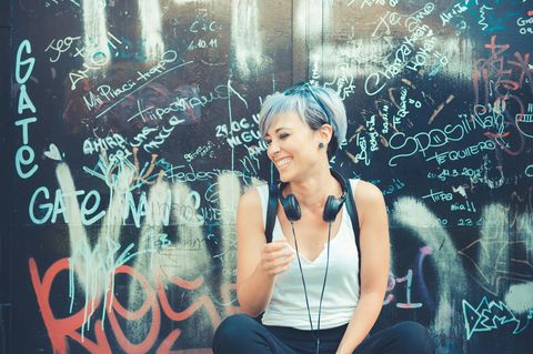 Mental Health: Eine fröhliche Frau mit Kopfhörern