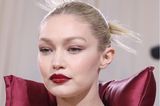 Mit Fokus auf ihre Lippen ergänzt Topmodel Gigi Hadid perfekt ihren dunkelroten Power-Suit. Eine strenge Frisur und eine große Statement-Kette machen den Beauty-Look der 27-Jährigen perfekt.