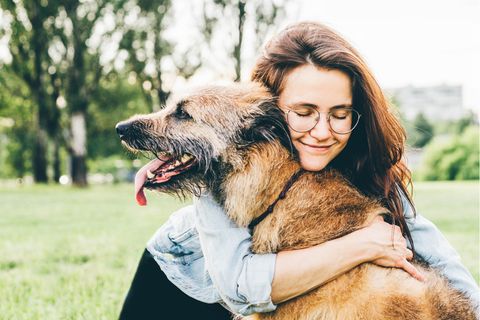 Eine Frau umarmt ihren Hund