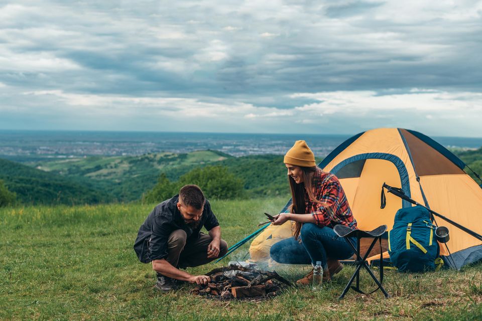 Zelt-Test: Diese Zelte überzeugen Camping- und Outdoor-Fans, Frau, Mann, Zelt, Lagerfeuer