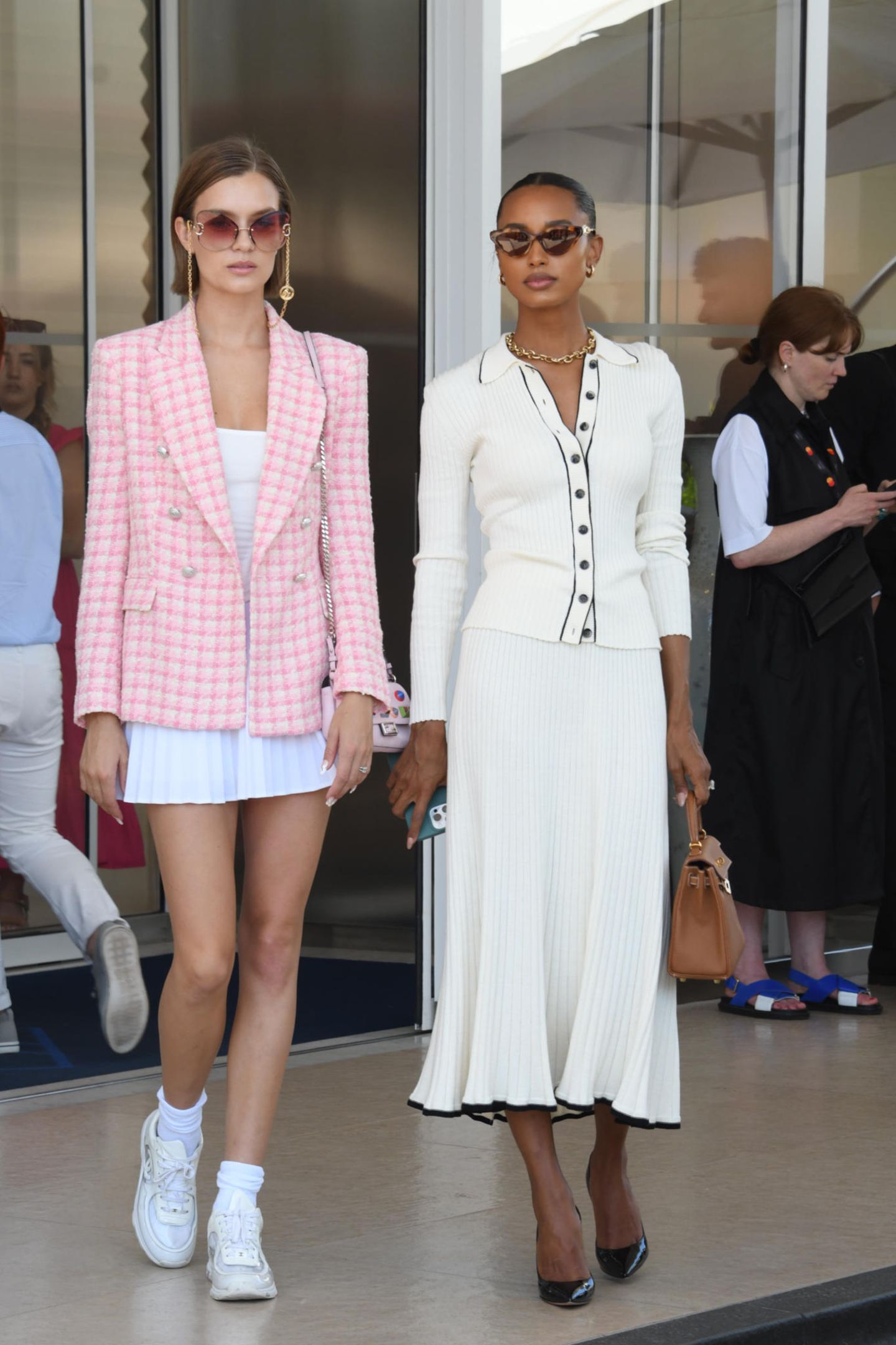 Ein stylisches Duo – Josephine Skriver und Model-Kollegin Jasmine Tookes ergeben ein cooles Bild zu zweit. Josephine trägt einen pink-karierten Blazer über einem weißen Mini-Kleid. Dazu kombiniert sie eine XXL-Sonnenbrille, die super zu ihrer neuen Haar-Veränderung passt. Jasmine Tookes trägt ein cremefarbenes Set aus Rock und Jacke, dazu eine hellbraune Handtasche.