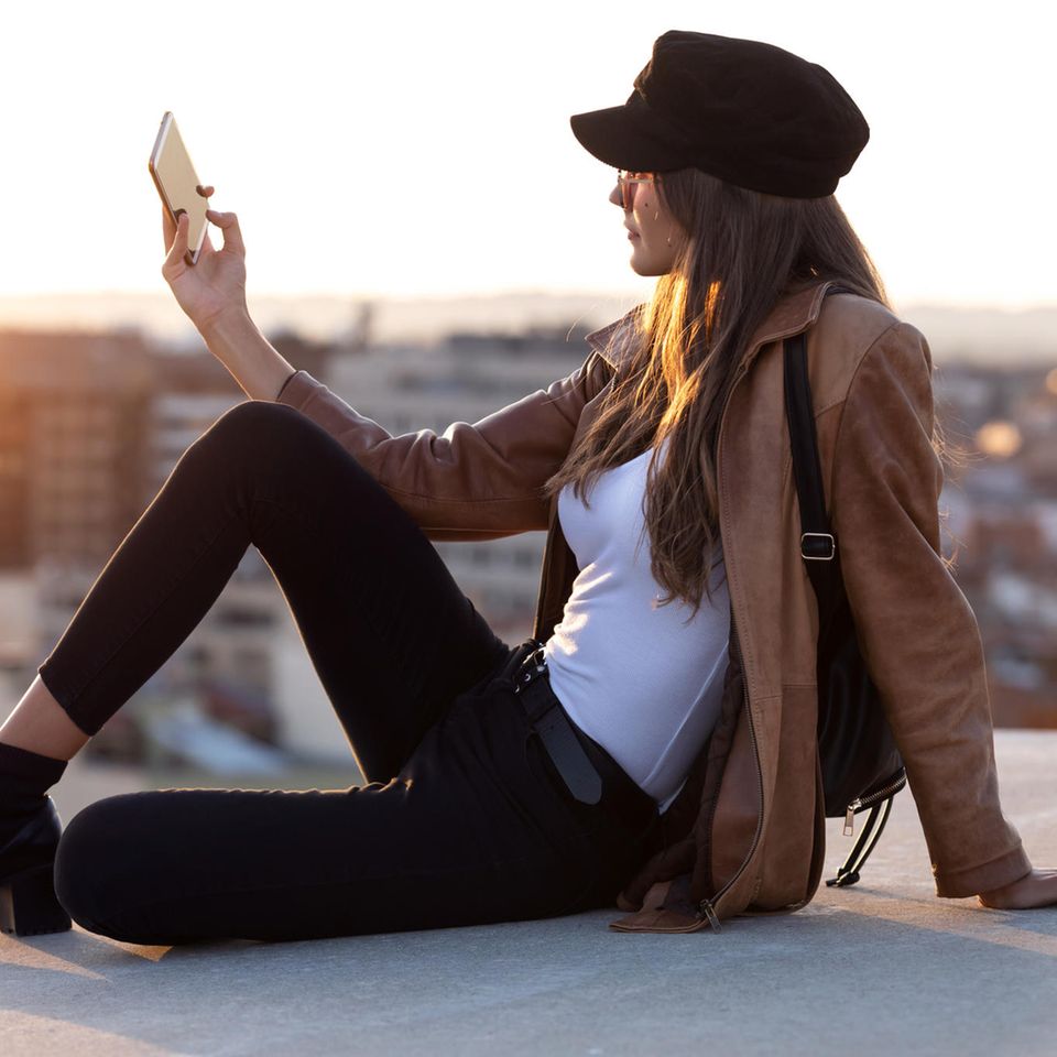 Alles Fake?: Frau macht ein Selfie auf einem Dach