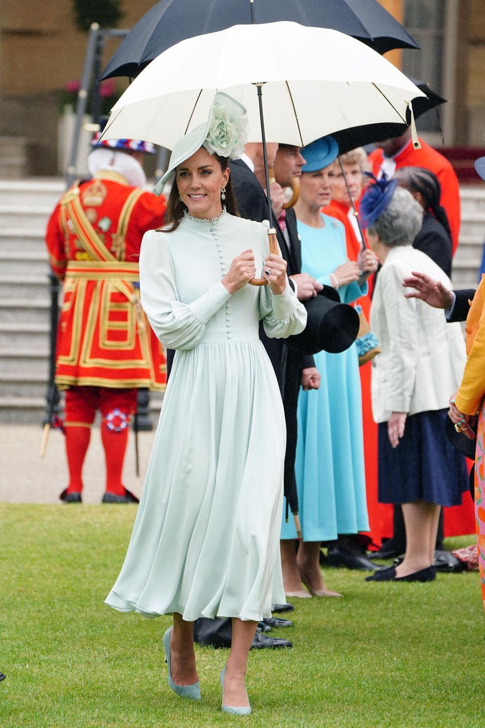 Es ist wieder Gartenparty Saison. Zur dritten Party im Buckingham Palast trägt Herzogin Catherine ein hochgeschlossenes Midi-Kleid mit Knopfleiste und Puffärmeln. Mit dem mintfarbenen Dress, hat Kate bereits in der Vergangenheit schon punkten können. Diesmal kombiniert sie einen farblich passenden Hut und Regenschirm dazu – wie ein Vollprofi! 
