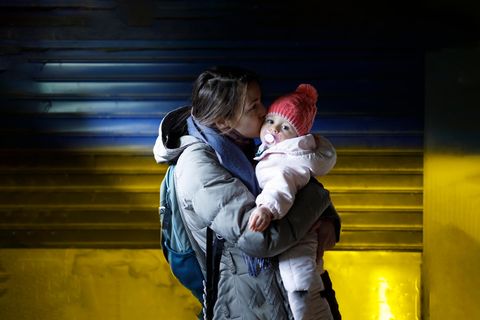 Flüchtlinge aufgenommen: Mutter küsst Kind vor Ukraine-Farben