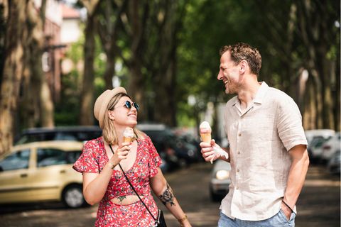 Frau und Mann essen Eis und lachen.