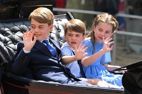 Prinz George, Prinz Louis und Prinzessin Charlotte winken während der Parade aus der Kutsche dem Publikum zu. 