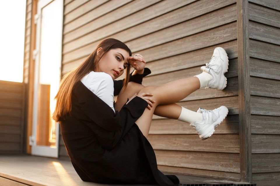 Eine junge Frau mit weißen Sneakern