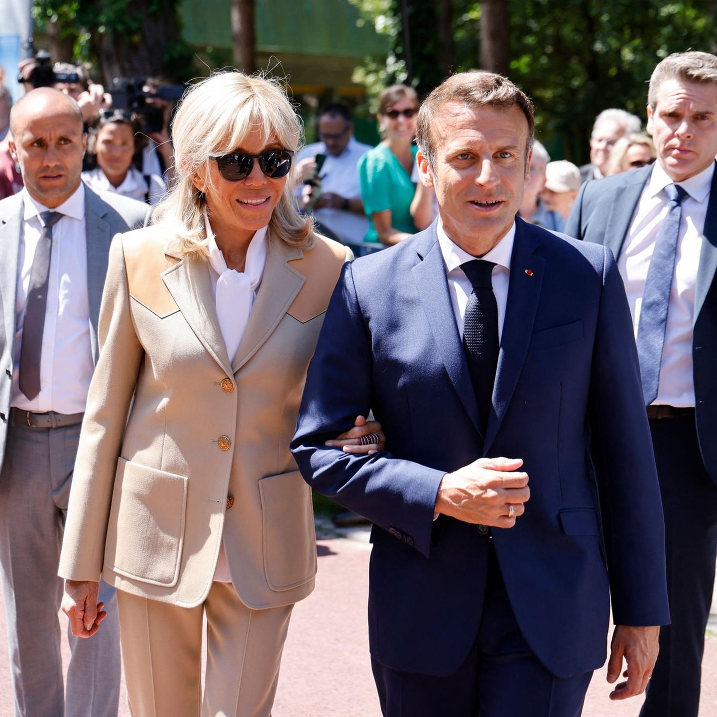 Zum Besuch eines Wahllokals stylt sich Brigitte Macron gewohnt elegant. Ihr Blazer in cremefarben ist tailliert geschnitten, bekommt durch Lederapplikationen an den Schultern ein interessantes Upgrade. Dazu trägt die Ehefrau des Amtsinhabers eine weiße Schluppenbluse.