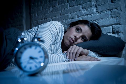 Die Angst vor dem Einschlafen: Frau liegt nachts schlaflos im Bett