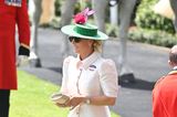 Wow, was für ein Look. Zara Tindall fährt in Ascot zu modischen Hochtouren auf. Zum beigefarbene Kleid von Laura Green London mit den pinkfarbenen Knöpfen kombiniert sie einen grünen Hut, der dem Look einen modernen Twist gibt. 