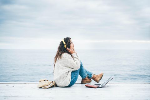 Frau mit Laptop am Meer | Pygmalion-Effekt: Warum wir uns meist so verhalten, wie andere es von uns erwarten