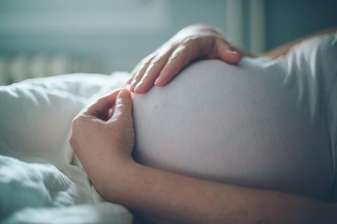 Schwangere Frau streichelt ihren Baby-Bauch