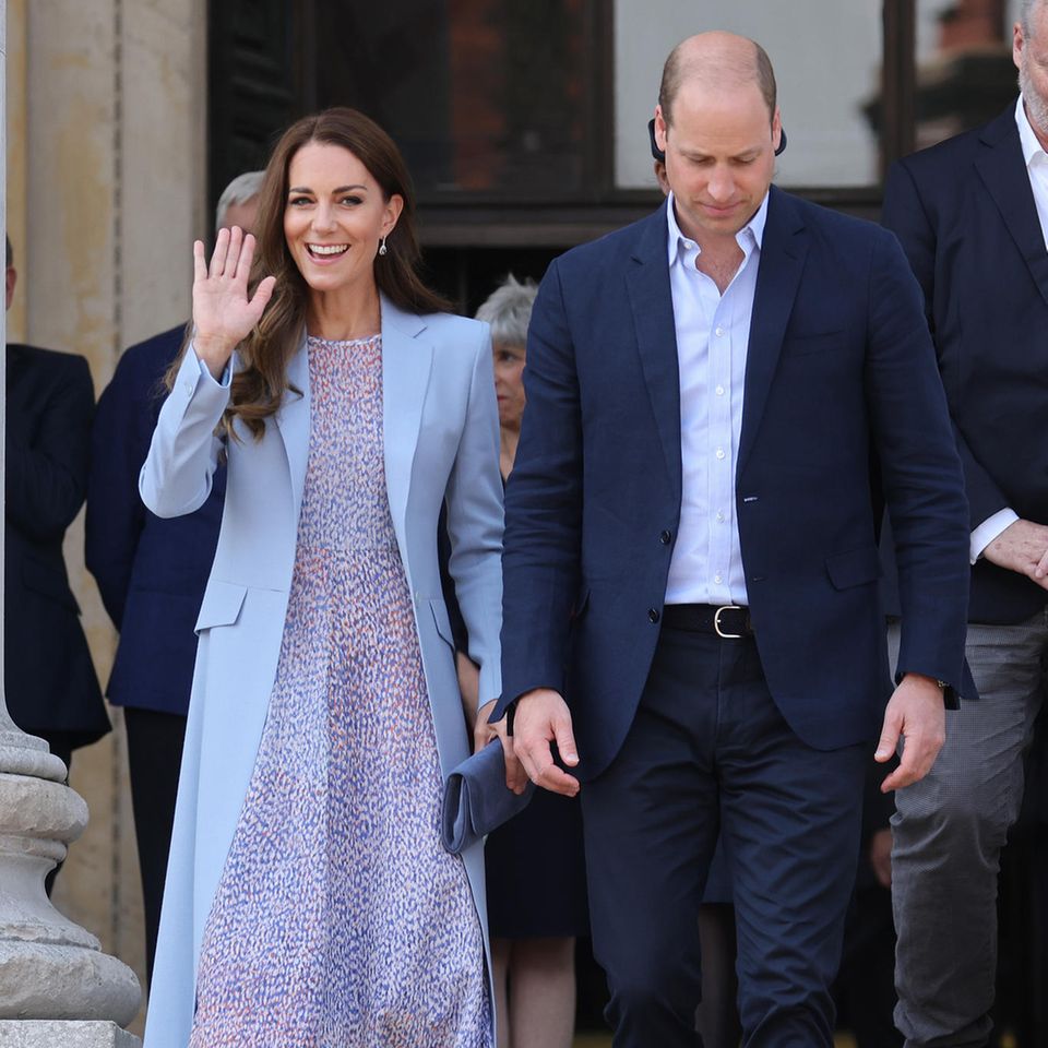 Prinz William und Herzogin Catherine besuchen den Cambridge County Day. Passend zum guten Wetter hat sich Kate für ein sommerliches Kleid von LK Bennett London entschieden. Dazu kombiniert sie einen hellblauen Mantel, der leicht tailliert ist und eine etwas dunklere Clutch von Emmy London. 