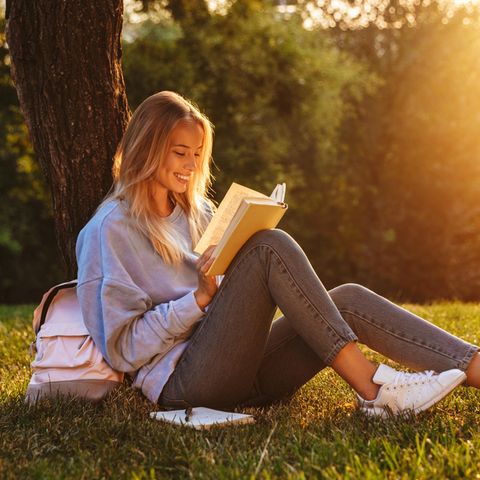 Buchtipps Sommer 2022: Frau liest unter einem Baum ein Buch