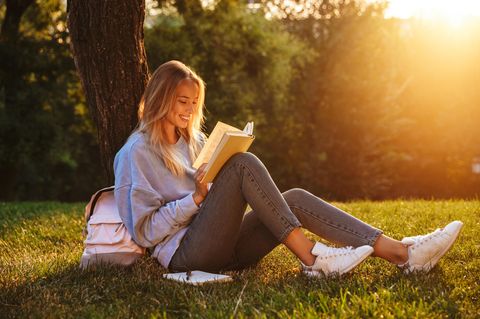 Buchtipps Sommer 2022: Frau liest unter einem Baum ein Buch
