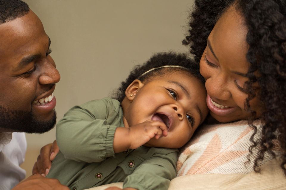 Die Kleinen stärken: Glückliche Eltern mit fröhlichem Baby