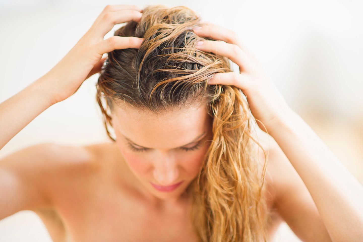 Klettenwurzel Haaröl: Frau massiert Öl ins Haar