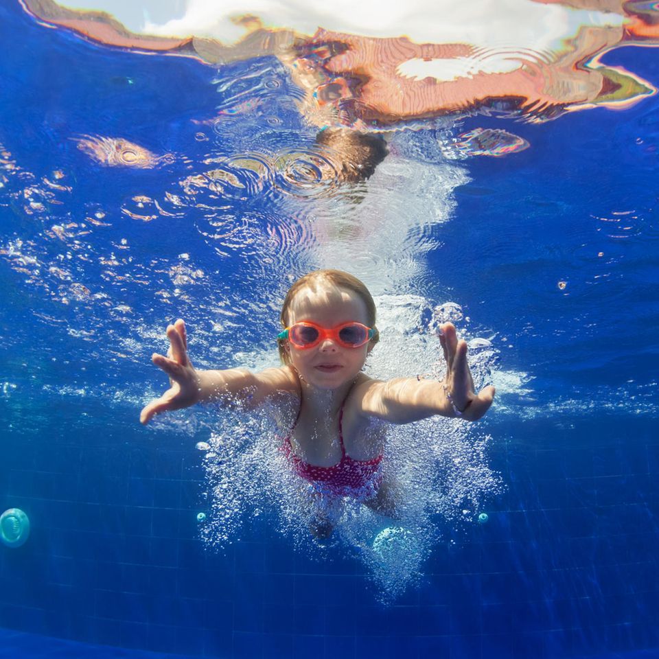 Mädchen mit Taucherbrille schwimmt in Pool