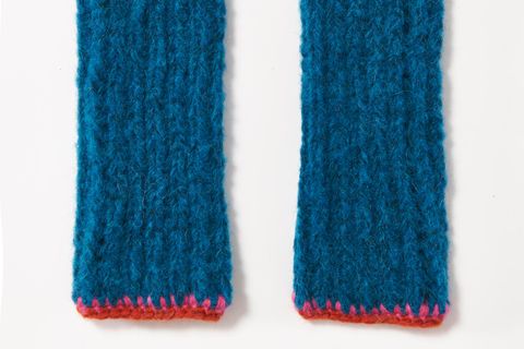 Armstulpen stricken: blaue Stulpen mit einem roten Rand