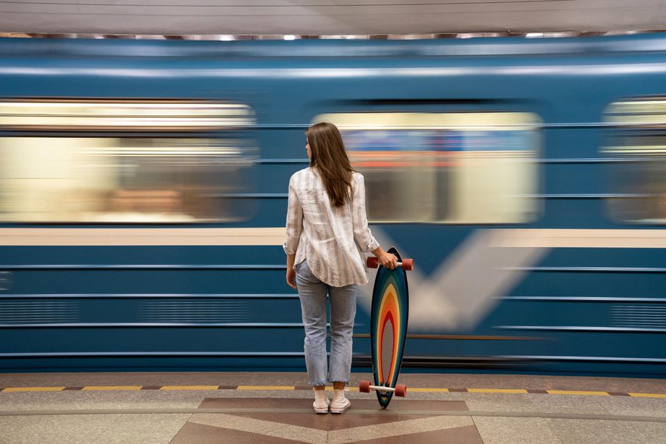 Alexandra Philipsen: eine junge Frau mit Skateboard stehen am Bahnsteig während eine Bahn schnell vorbei fährt
