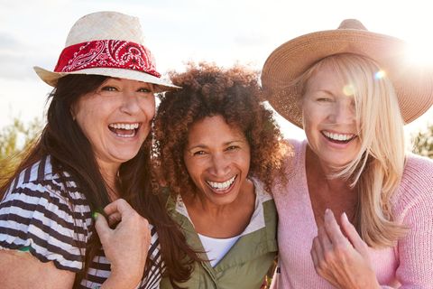 Drei Frauen lachen zusammen: Diese 4 Lebensereignisse können unsere Persönlichkeit als Erwachsene verändern
