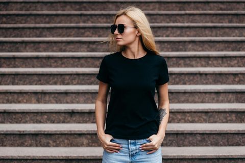Stylische Sonnenbrille von Tommy Hilfiger 31% reduziert, Frau in schwarzem Shirt und mit Sonnenbrille