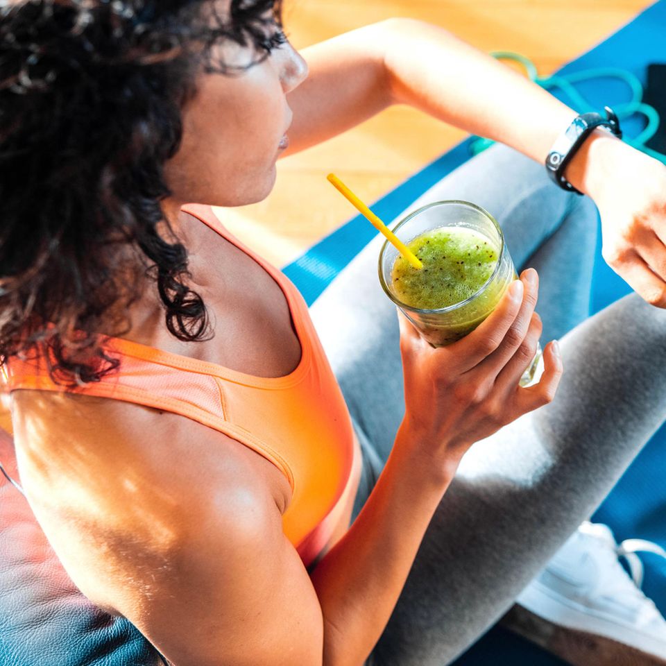 Frau trinkt nach dem Workout einen Smoothie | Forschende entdecken "Anti-Hunger-Molekül": Hemmt Sport wirklich unseren Appetit?