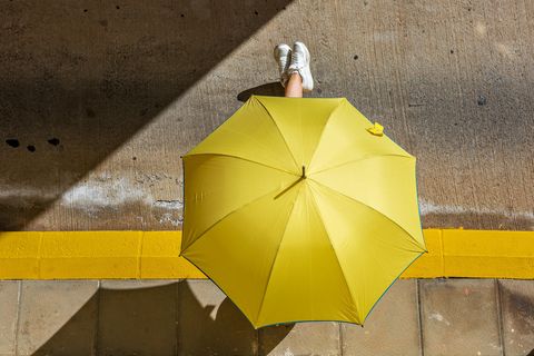 Prof. Dr. Claudia Traidl-Hoffmann: Person mit gelben Regenschirm in der Sonne