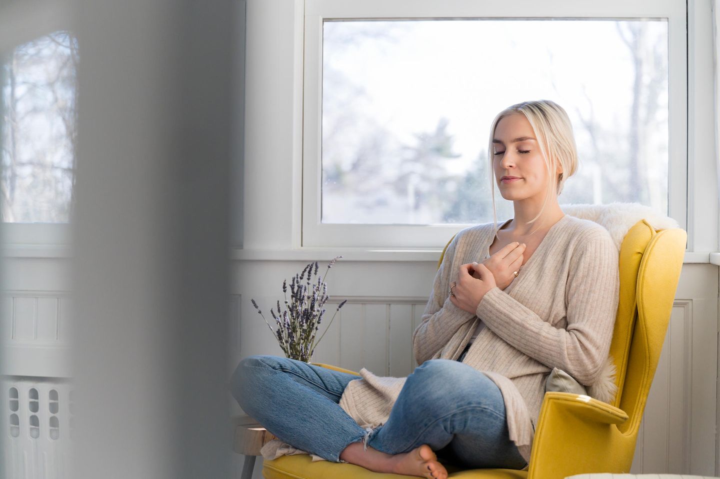 Atmen lernen: Frau sitzt auf einem Sessel und konzentriert sich auf die Atmung