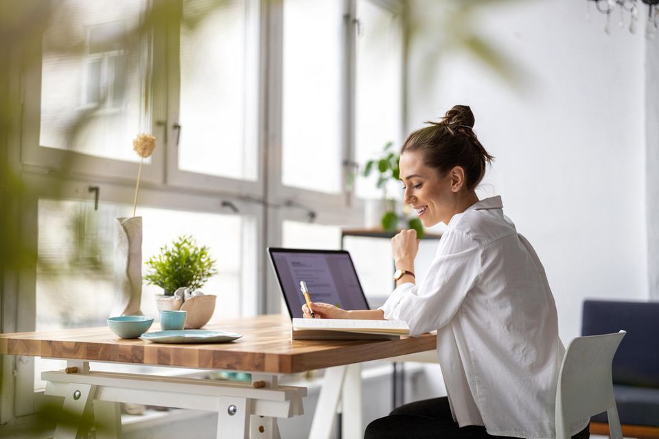 junge Frau sitzt am Schreibtisch im Homeoffice