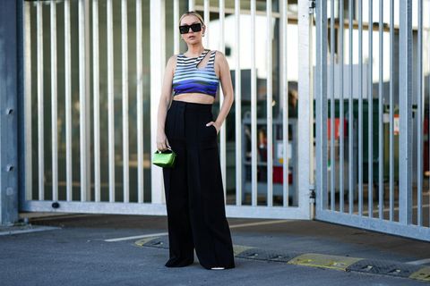 Die perfekte schwarze Hose: Frau trägt schwarze Hose und asymmetrisches Top