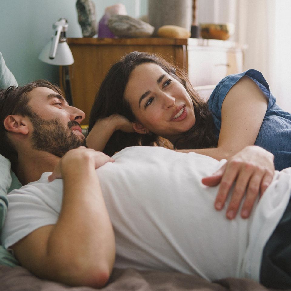 Über Sex reden: Mann und Frau sprechen auf dem Bett