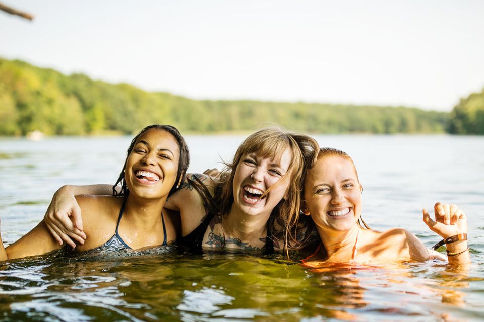 Drei Frauen posieren im Wasser für ein Foto.