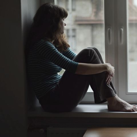 Single Kolumne: Nachdenkliche Frau sitzt am Fenster