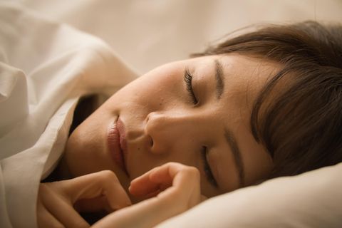 Frau schläft friedlich in ihrem Bett