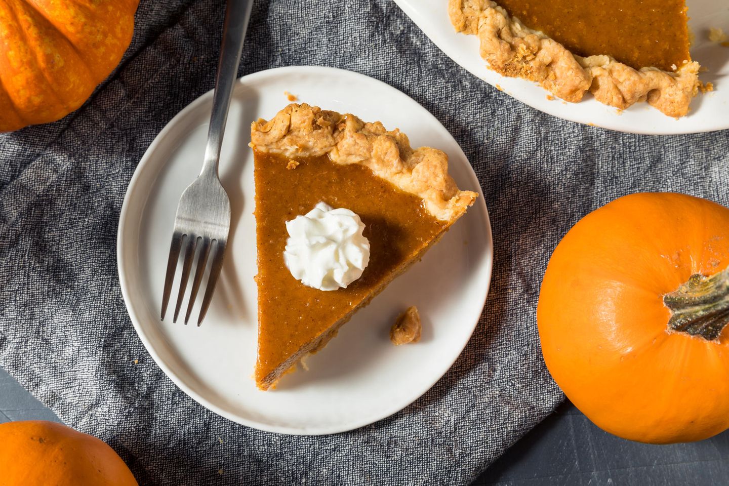 Herbstzeit: Ein Stück Kürbiskuchen angerichtet auf einem hübsch dekorierten Tisch