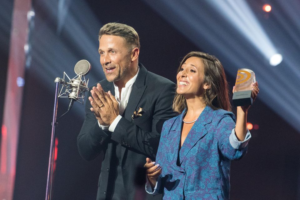 Florian Ambrosius und Vanessa Civiello stehen auf einer Bühne.