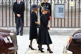 Herzogin Meghan und Gräfin Sophie kommen gemeinsam bei Westminster Abbey an. Beide tragen schwarze Trauerkleidung und Kopfbedeckungen. Besonders Meghans Look ist auffällig. Es scheint fast so, als hätte sie sich wieder einmal für ein Cape-Kleid von Stella McCartney entschieden. Das gleiche Modell, allerdings in Blau, trug sie das letzte Mal beim Geburtstagskonzert der Queen im Jahr 2018. 