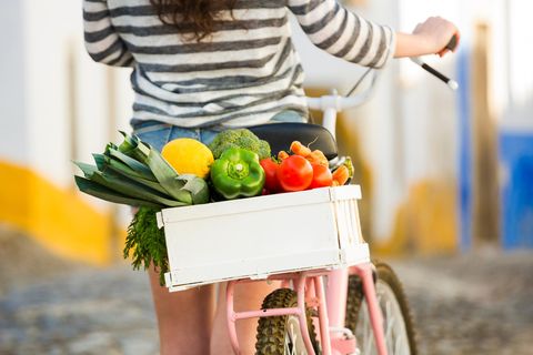 Energiespar-Hacks: Frau mit Lebensmitteln auf dem Fahrrad