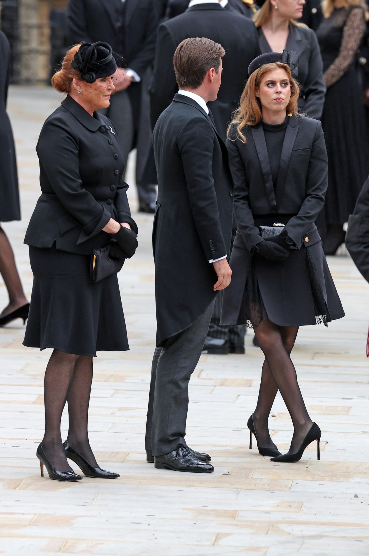 Prinzessin Beatrice trägt zum Kurzblazer von The Kooples ein schwarzes Kleid von Louis Vuitton. Das gleiche Modell hat Brigitte Macron am Vortag zum Staatsdinner getragen. 