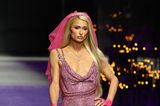 Bei der Show von Versace präsentiert Paris Hilton ein pinkfarbenes Glitzerkleid mit Schleier. Wie passend für das ehemalige It-Girl.