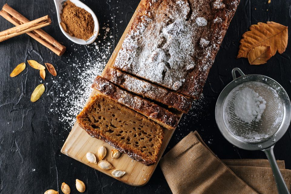 Ein Kürbis-Bananenbrot liegt auf einem Brett.