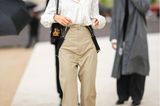 Iris Law, Tochter von Jude Law, kombiniert zur Dior-Show eine ausgestellte Stoff-Hose im Highwaist-Schnitt zur Oversized-Bluse. Hosenträger lässt das Model lässig an den Seiten herunterhängen. 