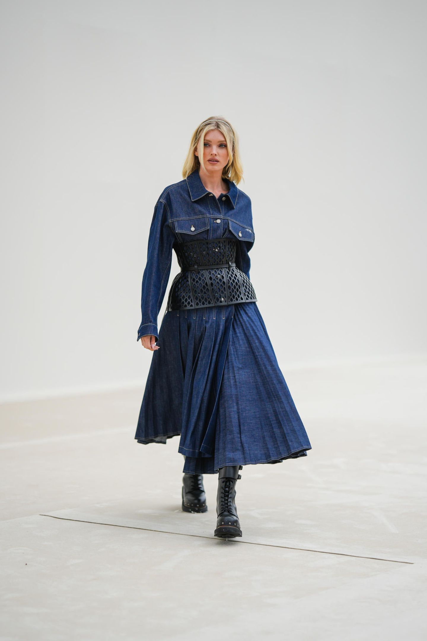 Elsa Hosk erscheint zur Dior Show am zweiten Tag der Paris Fashion Week in einem Jeans-Ensemble mit kunstvollem Taillengürtel. Derbe Boots mit Schnürungen runden den Lock ab. 